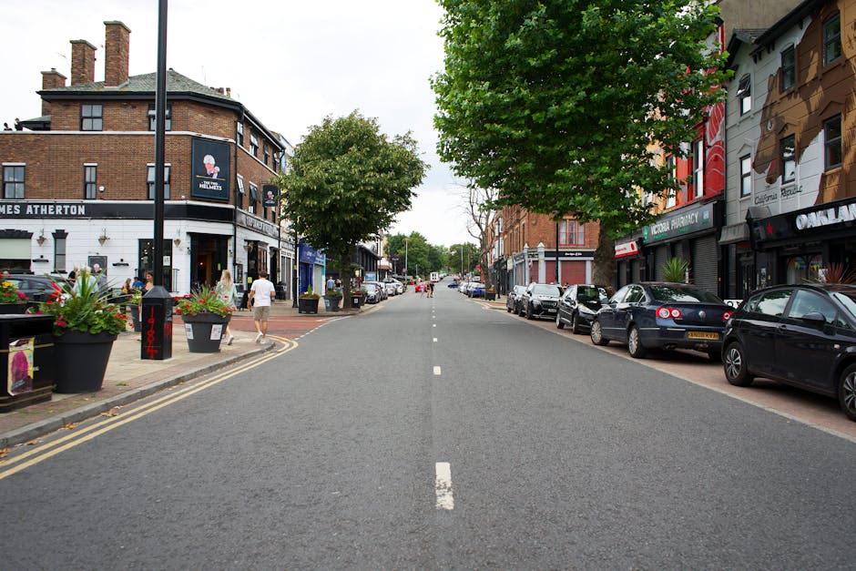 A street scene featuring a multi-story brick building with distinctive rounded turrets topped by metallic domes, located in Dulwich near Champion Hill. The building has numerous white-framed windows a